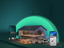 Modern house with solar panels on the roof, a glowing green energy arc, and smartphones displaying a home energy app.